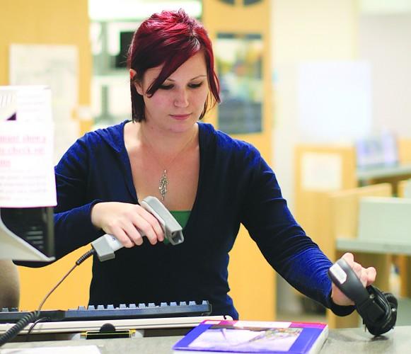 COCC student Rese Stec enjoys working as a library assistant at Barber Library because she can catch up on homework during downtime and "It's a good environment to be in."