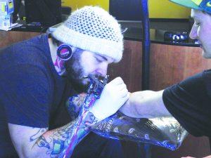 Nick Pulzone tattoos a client.