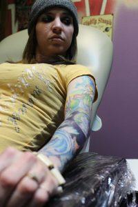 COCC student Ruthie Johnson waits for a touch-up on her tattoo.