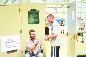 COCC student Chris Concannon stops to show his Mazama sticker to staffer Stuart Smith-Blockley before an open basketball session at Mazama Gym. Photo by Darwin Ikard | The Broadside