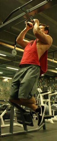 Sergio Felix performs pull-ups using the equipment in Mazama Gym.  Photo by James Miller II | The Broadside.