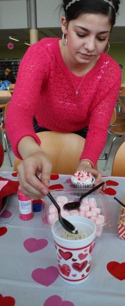 Kayla Miller, ASCOCC Director of Student Activities, helps out with cupcake decorating.  Photo by Vera Holiday | The Broadside.