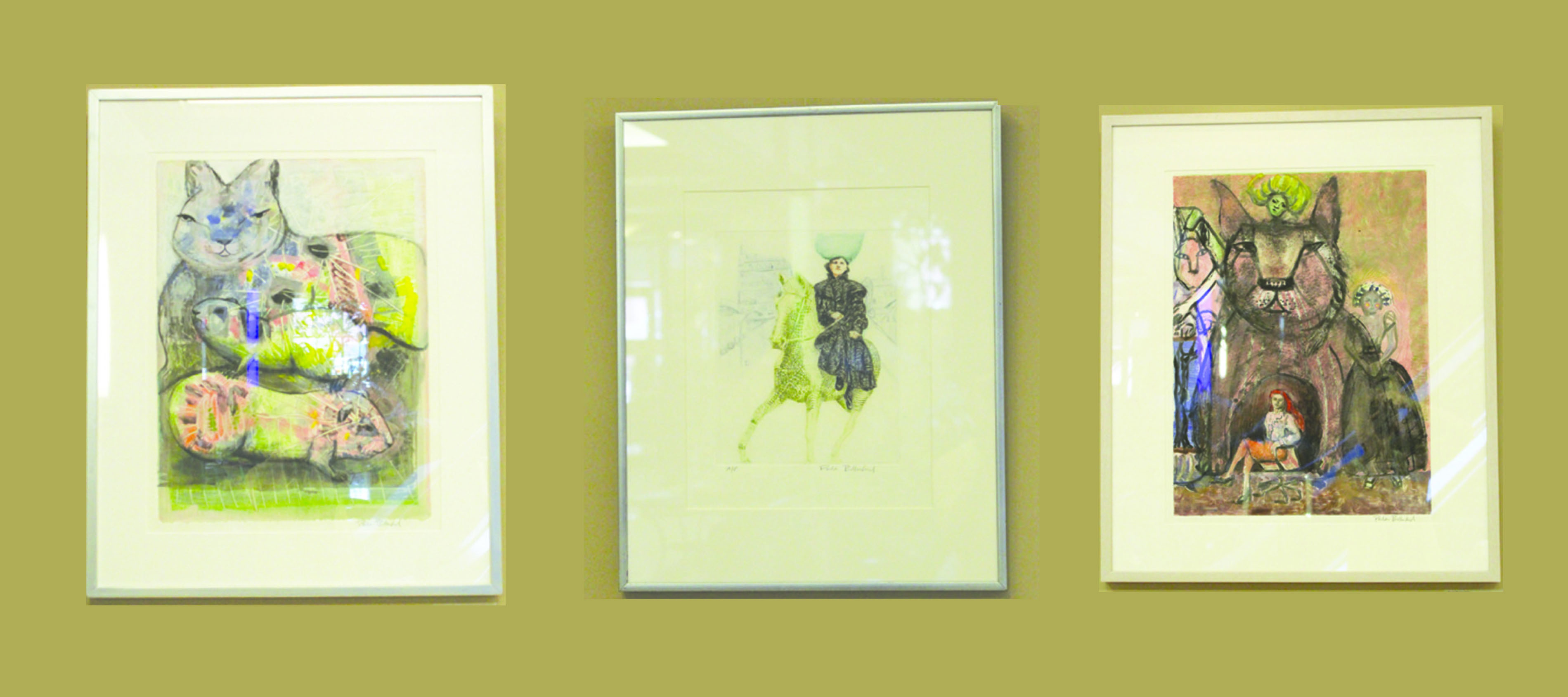 Artwork by Paula Bullwinkel displayed in the Franklin Crossing Atrium. Right: Family, Monotype with mixed-media. Center: Annie Rides, Etching. Left: Cat Cave, Monotype with mixed-media.