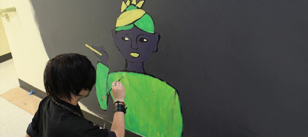 Zach Graves paints his interpretation of Zora Neil Herston during the Mural Painting Course.