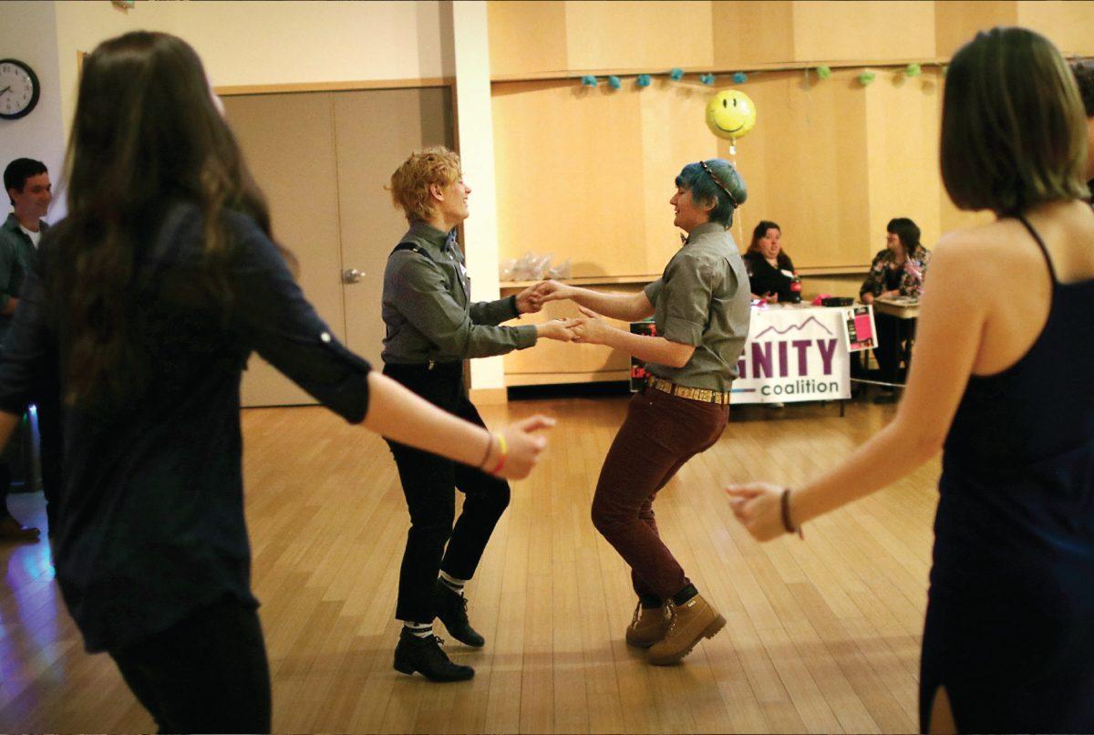 Surrounded by attendees of the dance, Belén Simpson [left] and Shayla Maffit dance together.