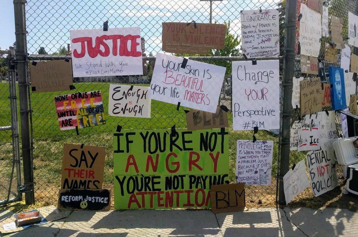 Protest signs tied to the fence outside of McMinamins  Bend, Oregon displaying phrases like  Enough is Enough and your silence is violence 