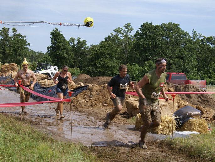 students running through a mud pit, photo provided by: USACE HQ