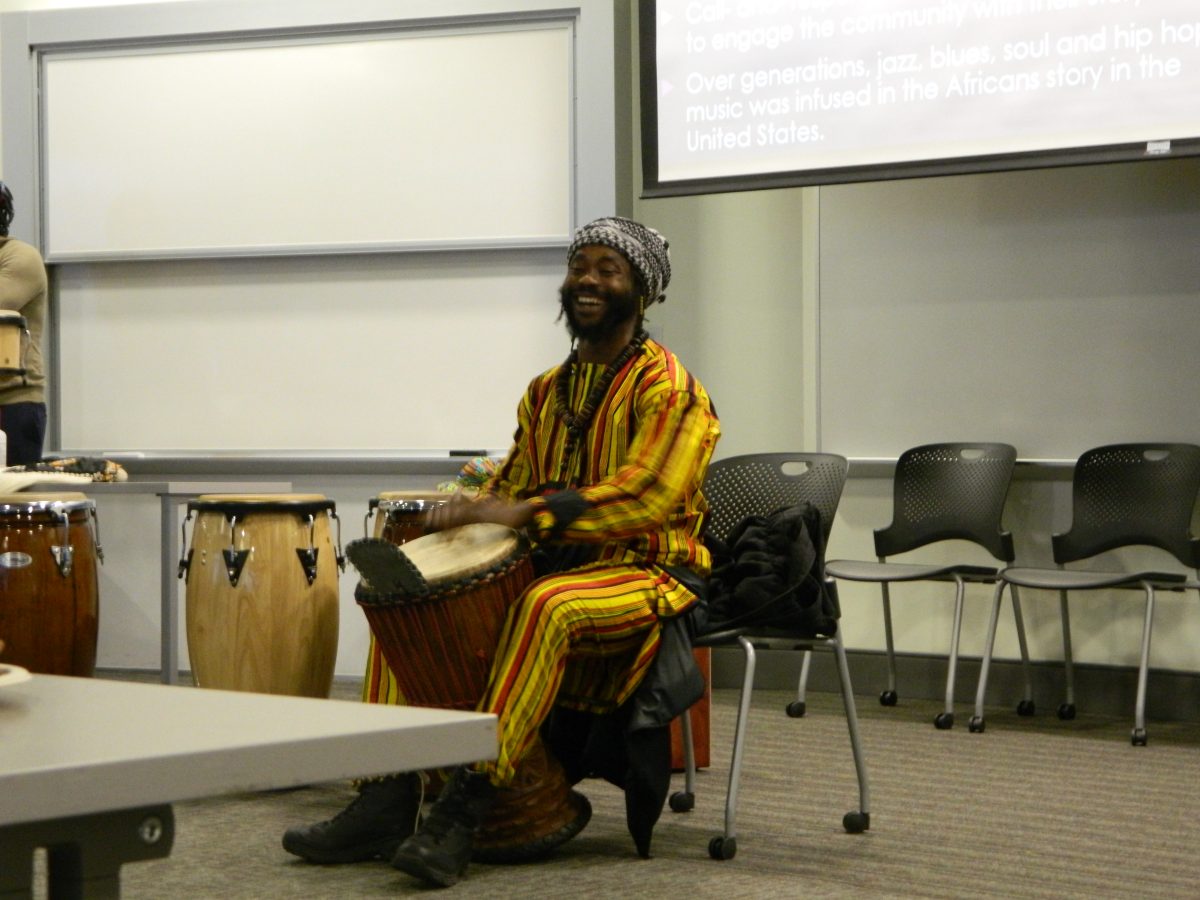Fodé Ismael Sylla demonstrating how to play the djembe for drum-making class attendees.
