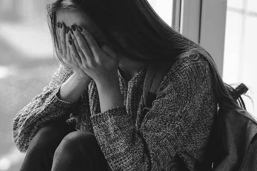 A young woman cries at school, as a result of being harassed.

Stock photography courtesy of Yta, Adobe Stock