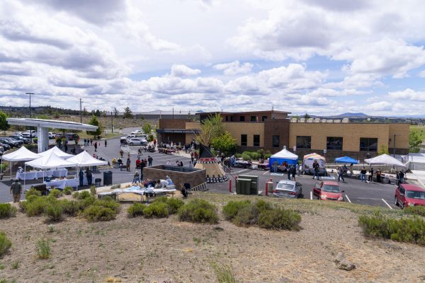 A teepee and a colorful array of tents are set up in the parking lot at the Madras campus.